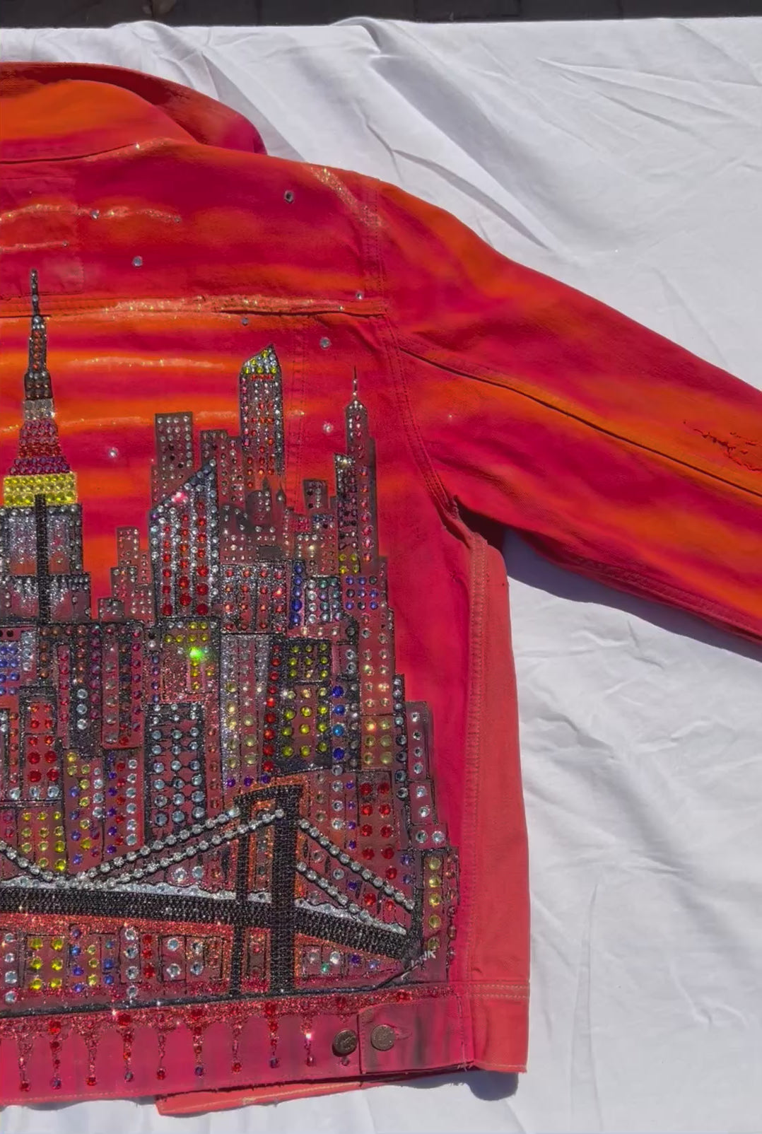 Orange Loria NYC Art jacket video with sun  reflecting on back