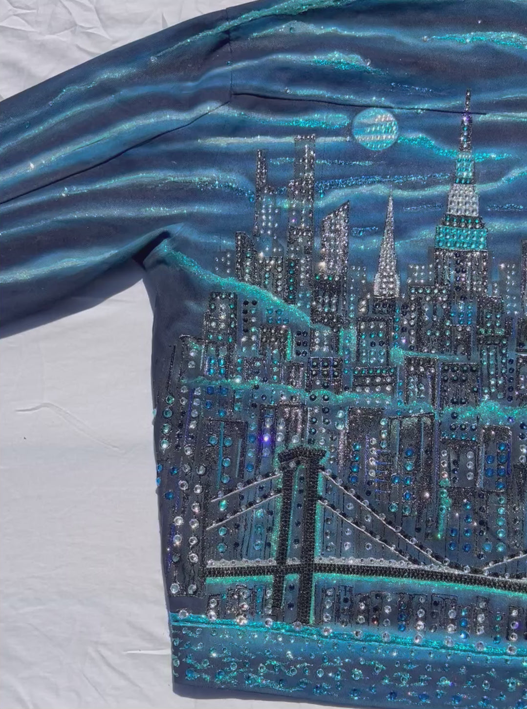 Blue colorful jacket with Loria NYC Art on a white background.