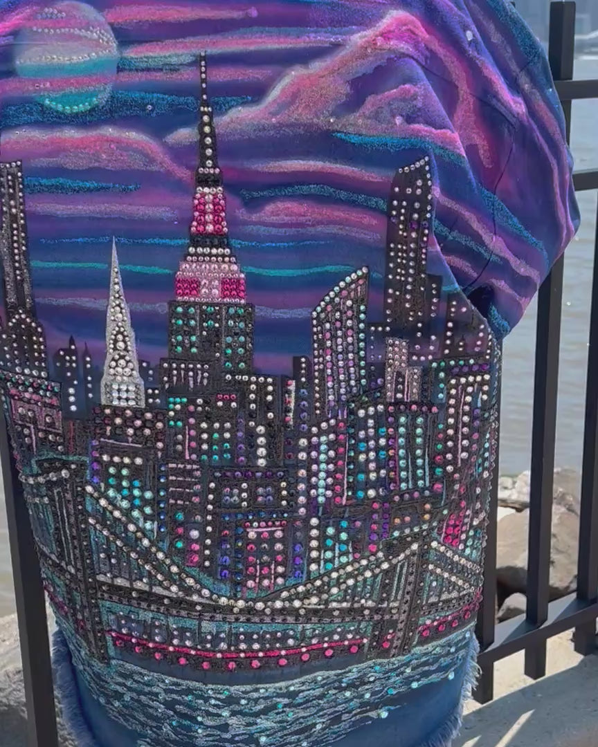 Person wearing a  wearable Loria NYC Art jacket with crystals with the skyline in background.