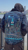 Man wearing a blue jacket with Loria NYC Art on back in a video with skyline in the background.