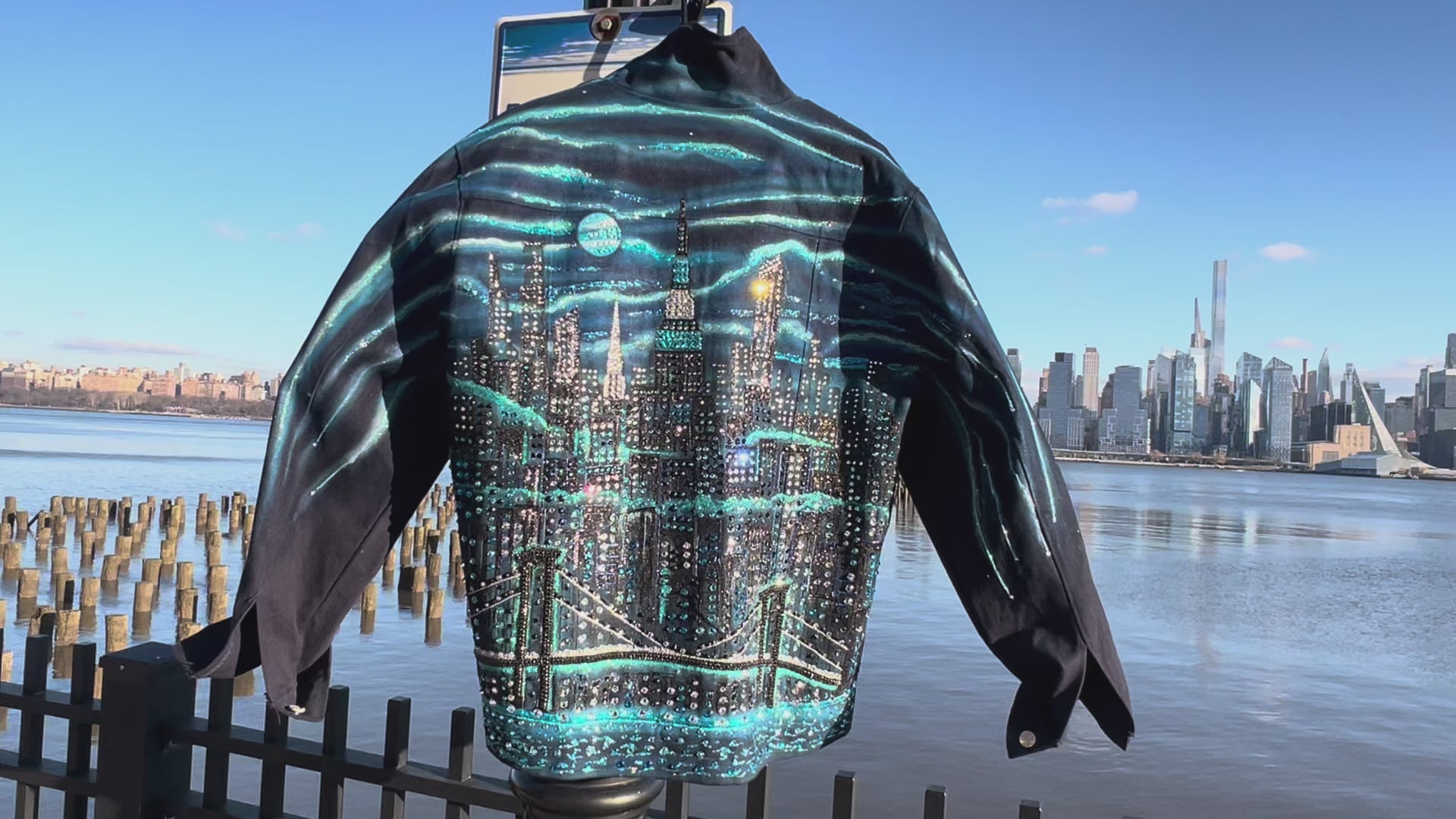 Back of detailed craft on blue denim jacket covered in Loria NYC Art with colorful skyline on a sunny day