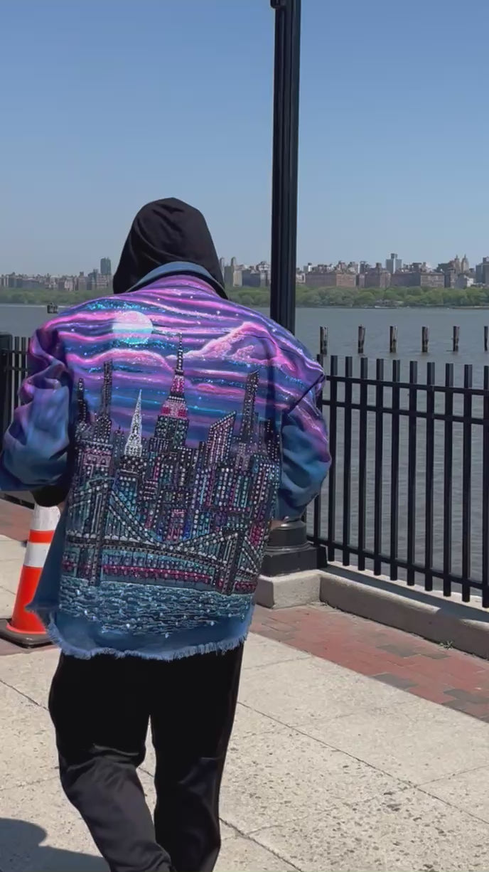 Man walking by the Hudson River in a colorful Loria NYC Art jacket with crystals reflecting in sunlight.