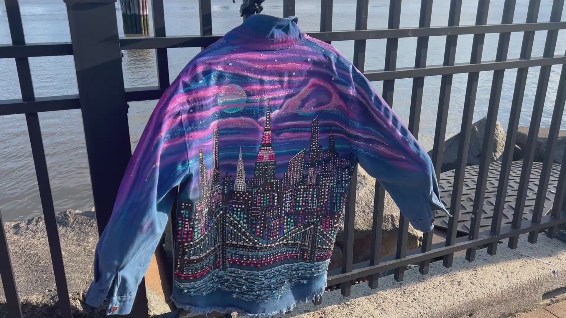 Close up Video of a  colorful Loria NYC Art jacket with the city skyline in the background 