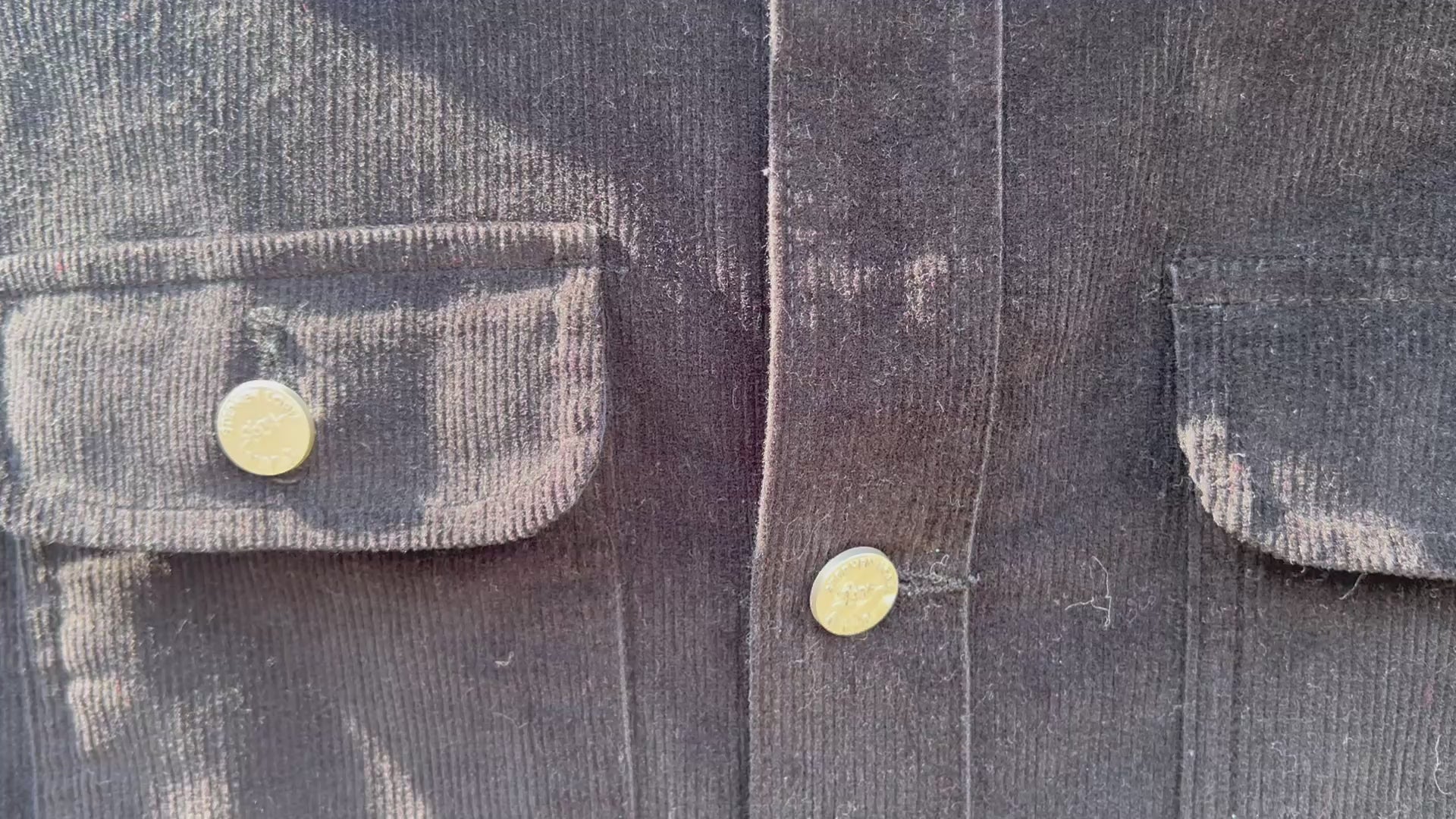 Video of the front of a blue corduroy jacket with Loria NYC Art butons