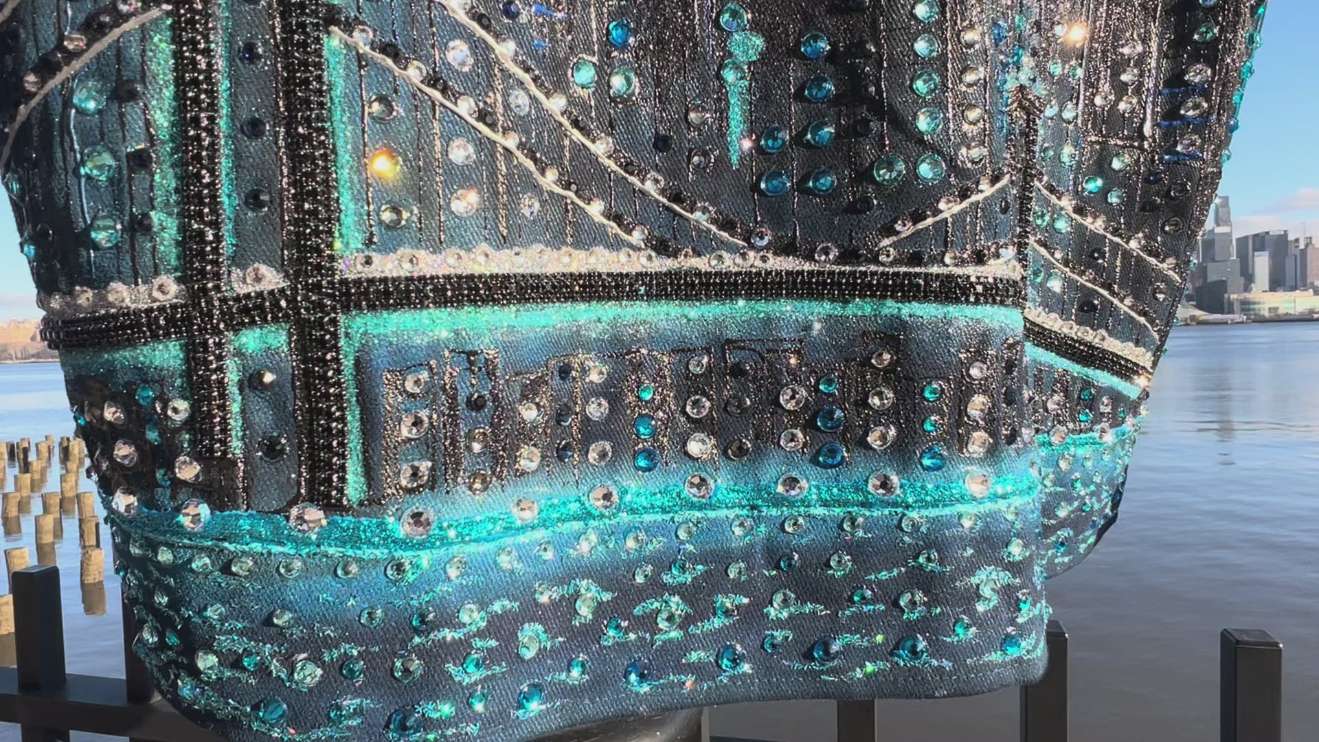 Detailed Video on a clear day of a  jacket covered in Loria NYC Art with skyline background