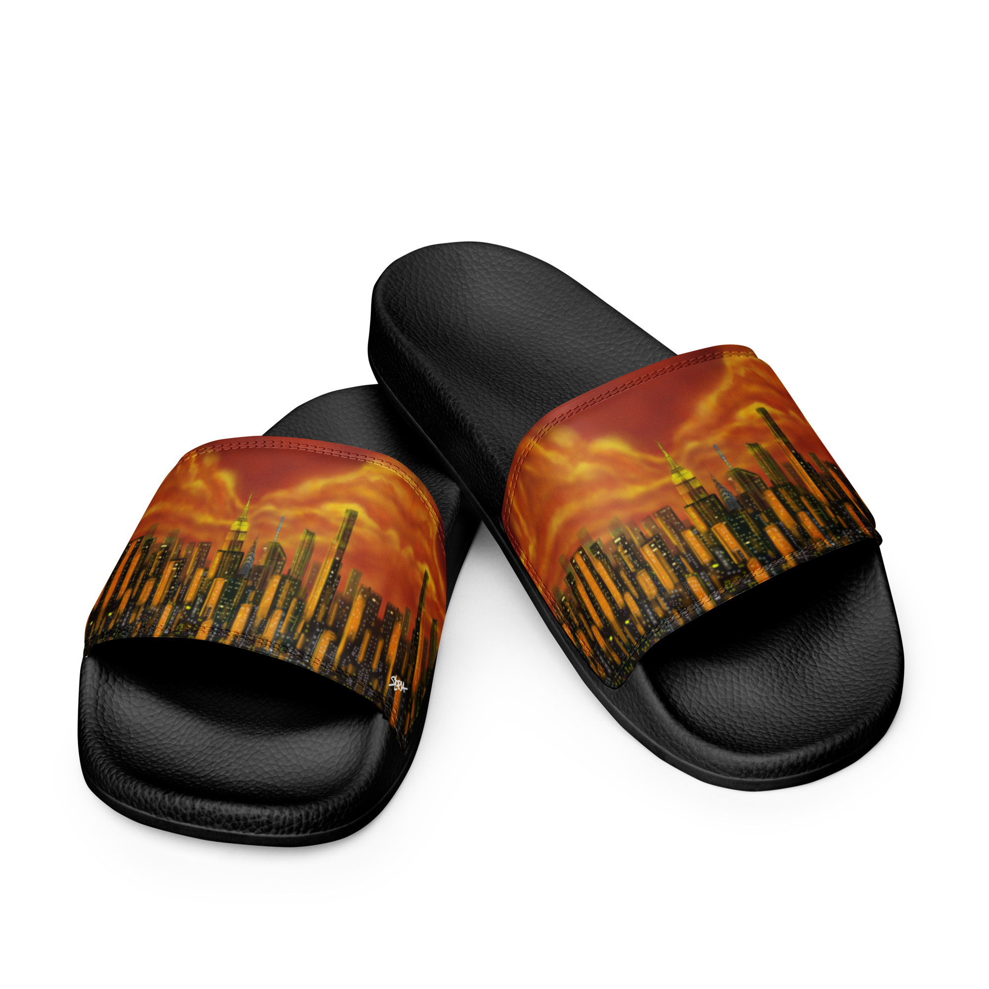 Black slide sandals with a fiery Loria NYC Art cityscape design on a white background