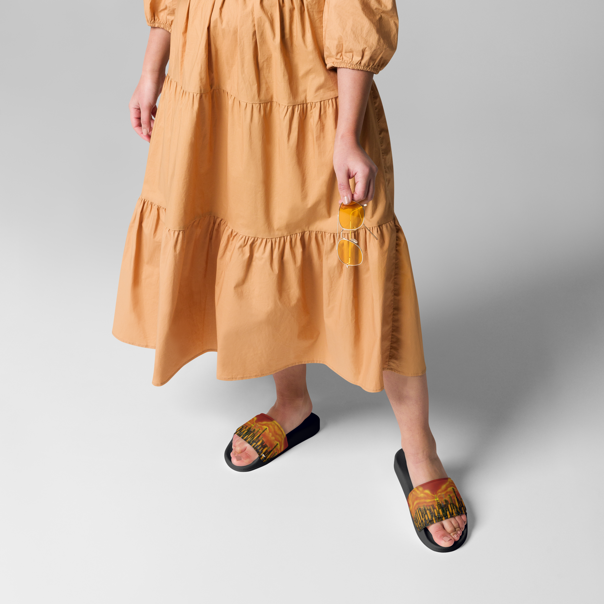 Person wearing a mustard yellow dress and Loria NYC Art sandals on a plain background