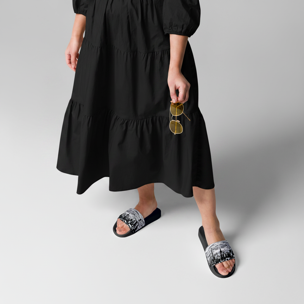 Person wearing a mustard yellow dress with black Loria NYC Art sandals on a light gray background